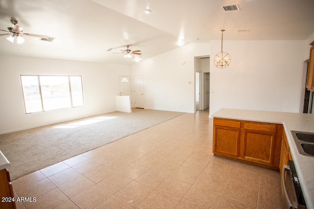 kitchen with pendant lighting, ceiling fan with notable chandelier, light colored carpet, and lofted ceiling