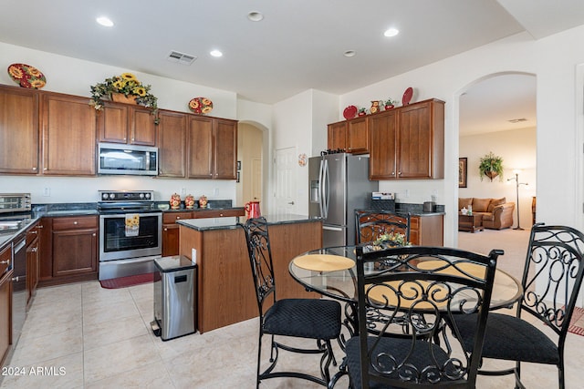 kitchen featuring stainless steel appliances, light tile patterned flooring, and a kitchen island