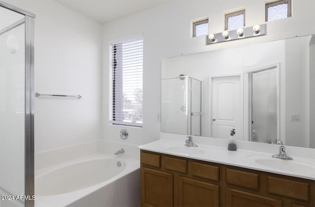 bathroom featuring a shower stall, a garden tub, and a sink