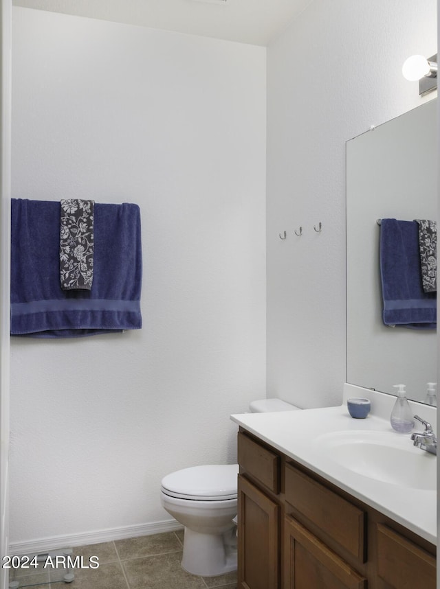 half bathroom with vanity, toilet, and tile patterned flooring