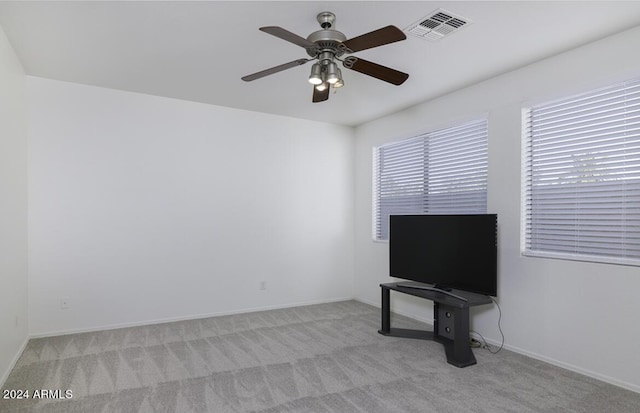 carpeted living area featuring a ceiling fan, visible vents, and baseboards