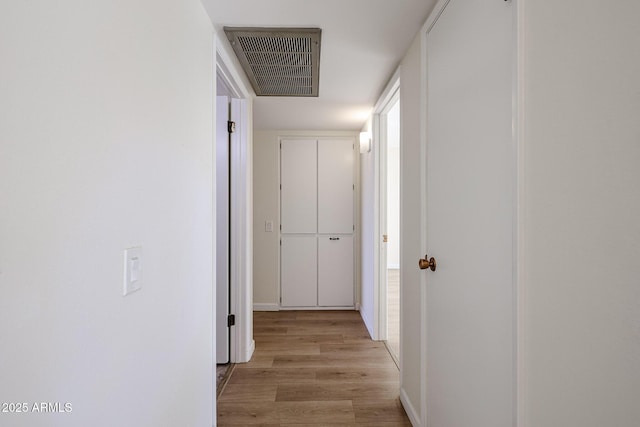 corridor with light wood-type flooring and visible vents