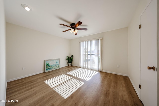 unfurnished room featuring baseboards, wood finished floors, and a ceiling fan