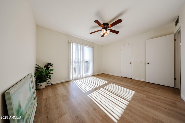 unfurnished room featuring a ceiling fan, baseboards, and light wood-style floors