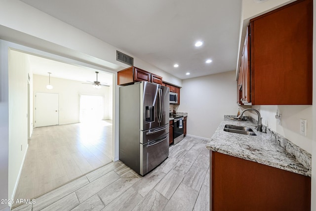 kitchen with visible vents, ceiling fan, stainless steel appliances, a sink, and light wood-type flooring