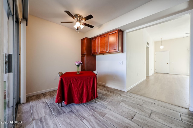 dining space with light wood-type flooring, baseboards, and ceiling fan
