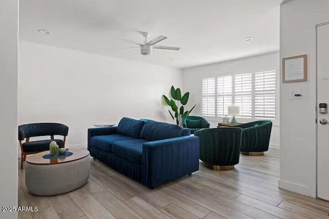 living room with light hardwood / wood-style floors and ceiling fan