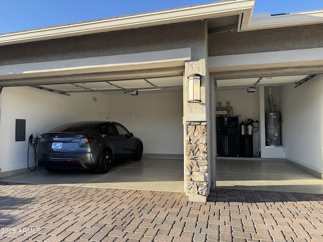 garage featuring decorative driveway and water heater