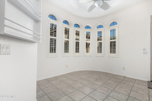 tiled empty room featuring ceiling fan