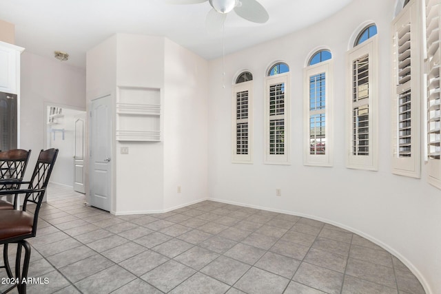 interior space with ceiling fan and light tile patterned flooring