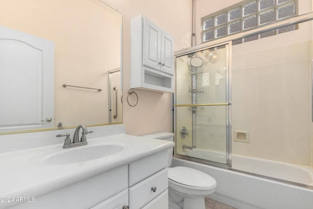 full bathroom with vanity, enclosed tub / shower combo, and toilet