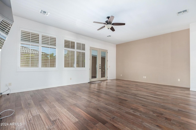 spare room featuring dark wood-type flooring, ceiling fan, and french doors