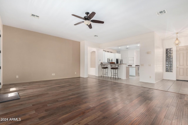 unfurnished living room featuring ceiling fan and light hardwood / wood-style floors