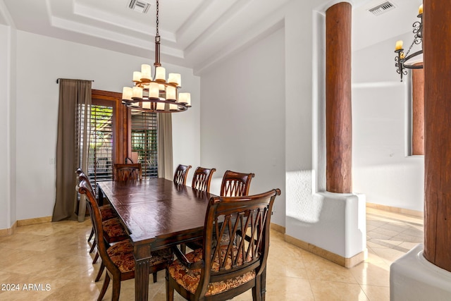 dining area featuring a tray ceiling, light tile patterned floors, and a notable chandelier