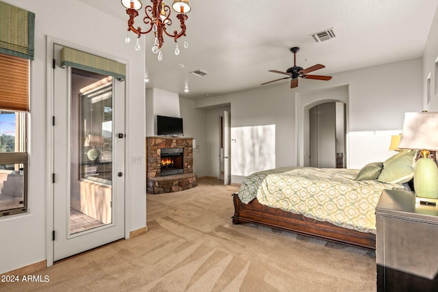 bedroom featuring a fireplace, access to outside, ceiling fan with notable chandelier, and light colored carpet