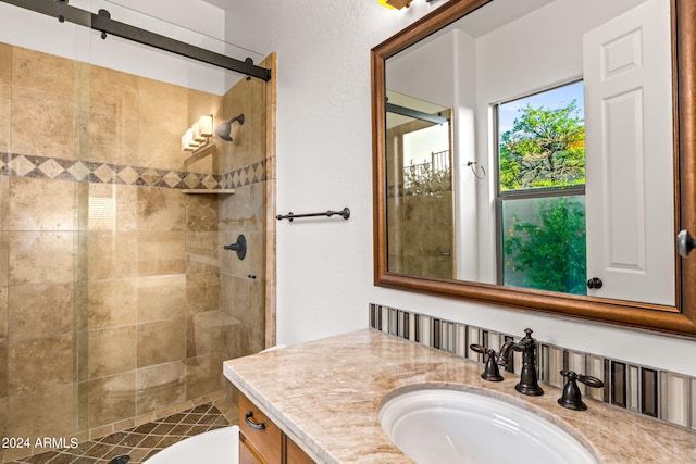 bathroom featuring tiled shower, vanity, and toilet