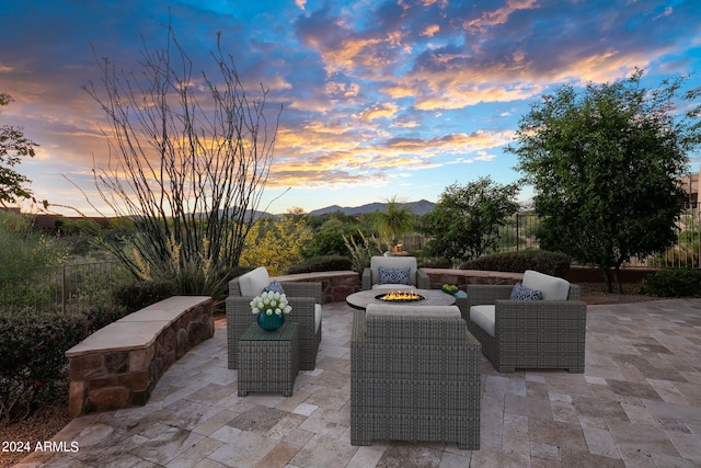 patio terrace at dusk featuring a fire pit and a mountain view