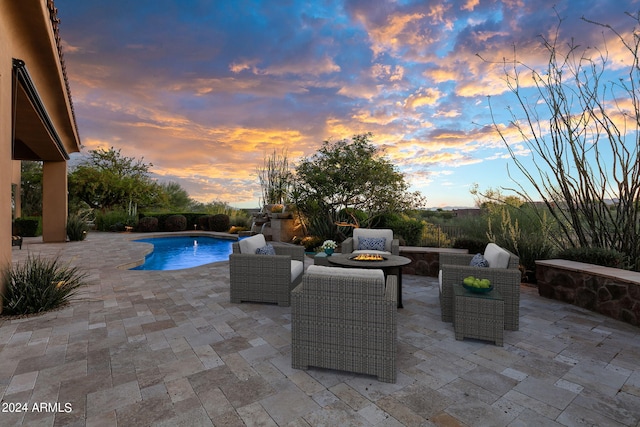 pool at dusk featuring a fire pit and a patio area