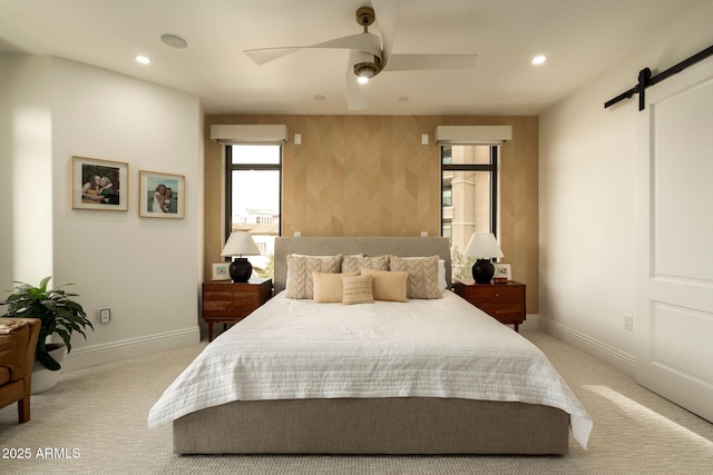 bedroom featuring a barn door, baseboards, and carpet flooring