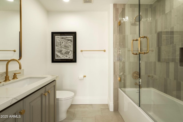 bathroom with baseboards, toilet, enclosed tub / shower combo, tile patterned flooring, and vanity