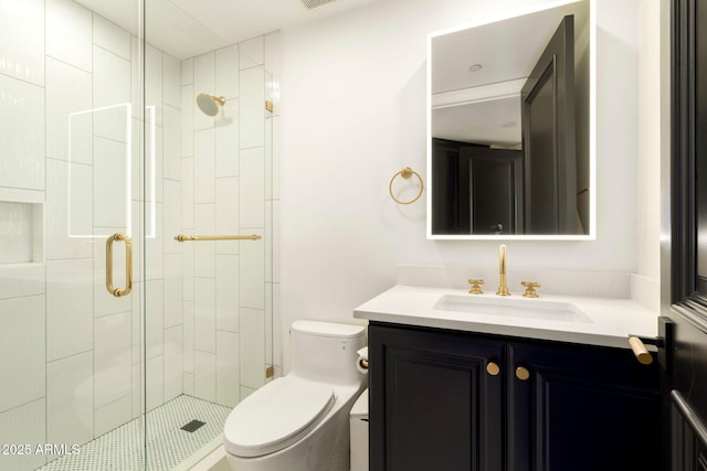 bathroom with toilet, a stall shower, and vanity