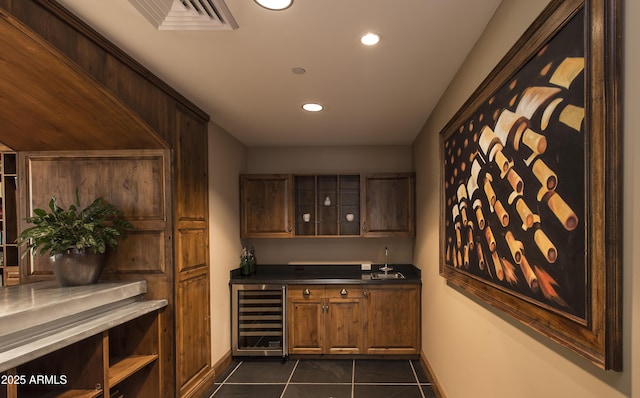 wine area featuring beverage cooler, visible vents, dark tile patterned flooring, indoor wet bar, and recessed lighting