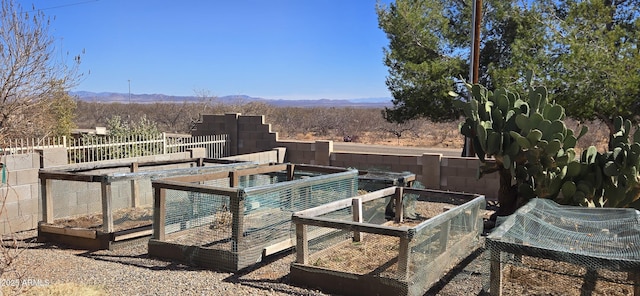 exterior space featuring fence, a vegetable garden, and a mountain view