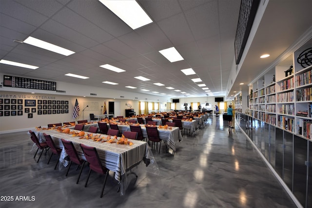 miscellaneous room featuring a paneled ceiling and finished concrete flooring