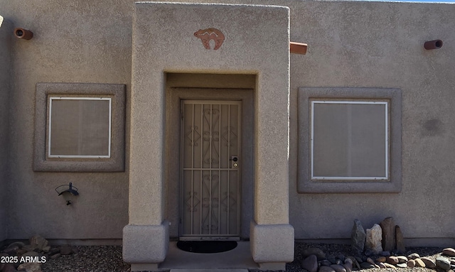 property entrance with stucco siding