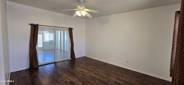 empty room with dark wood-type flooring, baseboards, and a ceiling fan