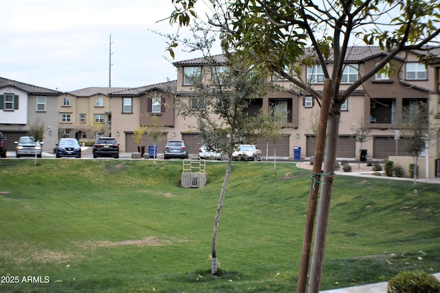 view of community featuring an attached garage and a lawn