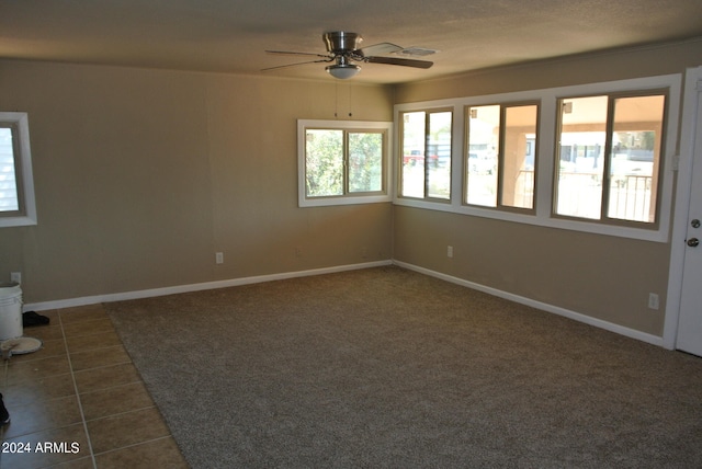 tiled spare room with a wealth of natural light and ceiling fan