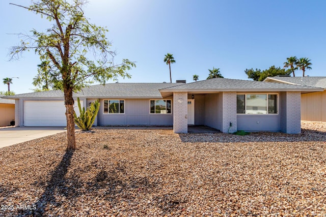 ranch-style home with a garage, brick siding, roof with shingles, and driveway