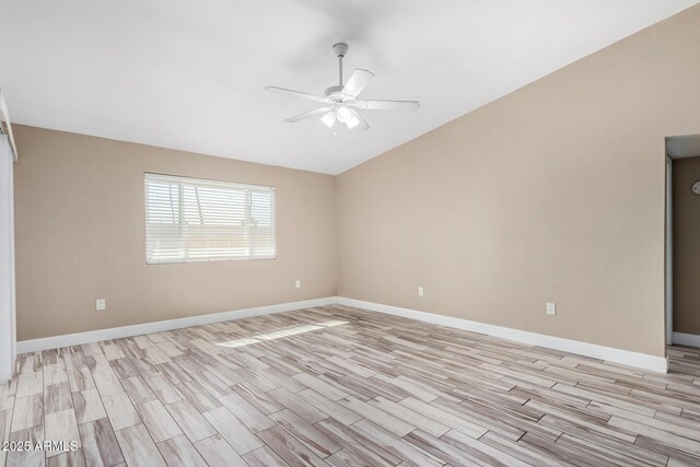 empty room featuring lofted ceiling, baseboards, light wood-type flooring, and ceiling fan