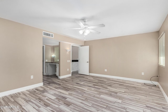 unfurnished bedroom with a ceiling fan, baseboards, visible vents, ensuite bath, and light wood-type flooring