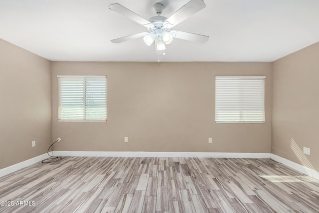 empty room with a ceiling fan, light wood-style floors, and baseboards