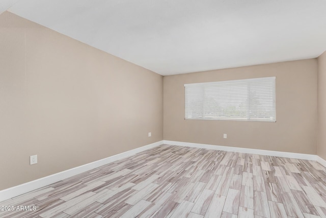 empty room featuring light wood-type flooring and baseboards