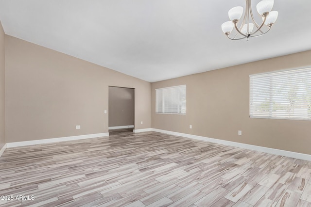 unfurnished room featuring light wood-style flooring, baseboards, lofted ceiling, and an inviting chandelier