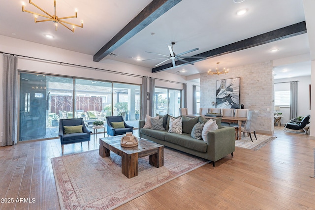 living area featuring ceiling fan with notable chandelier, light wood-style flooring, beam ceiling, and recessed lighting