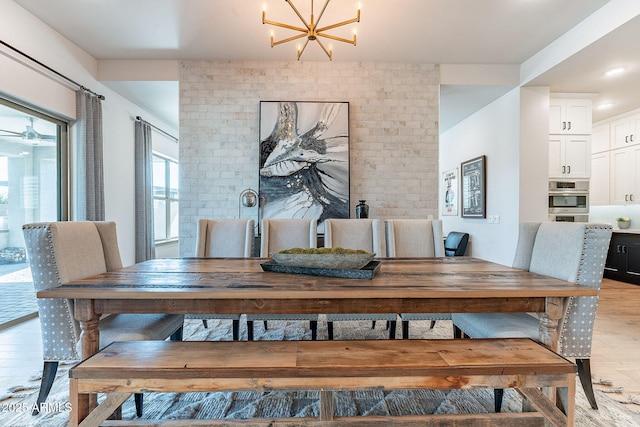 dining space featuring light wood-type flooring and a chandelier