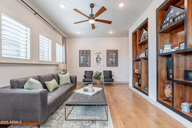 living room featuring baseboards, a ceiling fan, wood finished floors, built in shelves, and recessed lighting