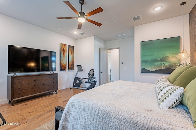 bedroom featuring a ceiling fan, visible vents, baseboards, and wood finished floors