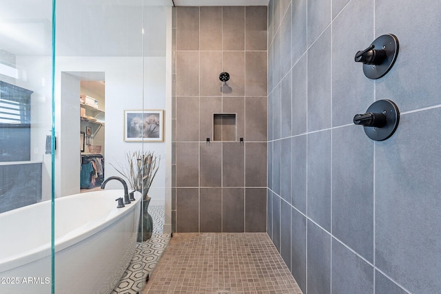 full bath with a tile shower and a freestanding tub