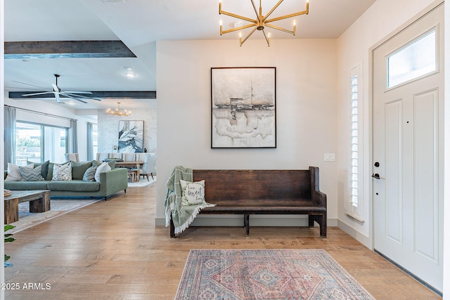 foyer with wood finished floors, baseboards, beam ceiling, and an inviting chandelier