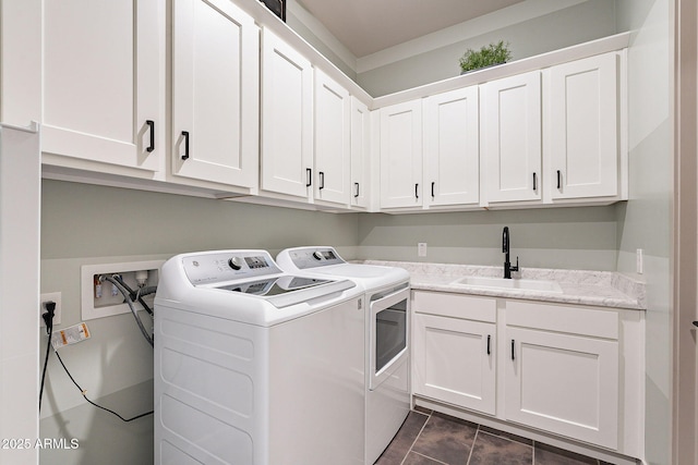 clothes washing area featuring washing machine and dryer, a sink, and cabinet space