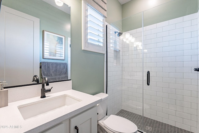 bathroom with a shower stall, toilet, and vanity