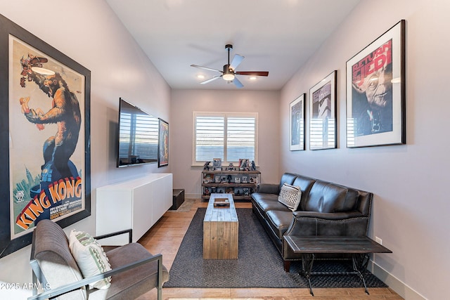 living area with ceiling fan, light wood-style flooring, and baseboards