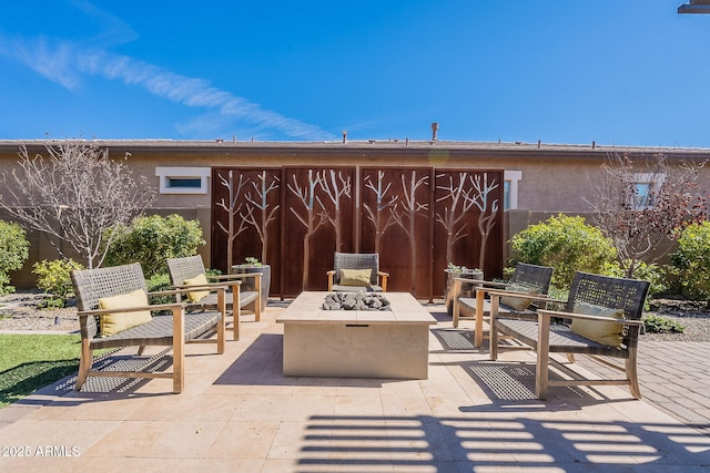 view of patio / terrace featuring an outdoor fire pit and fence