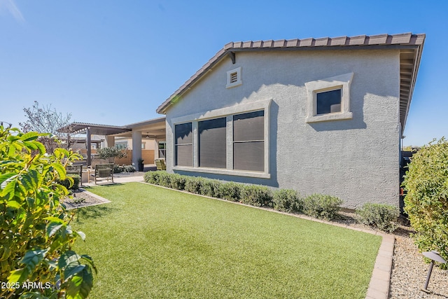 rear view of house with a lawn, fence, a patio area, a pergola, and stucco siding