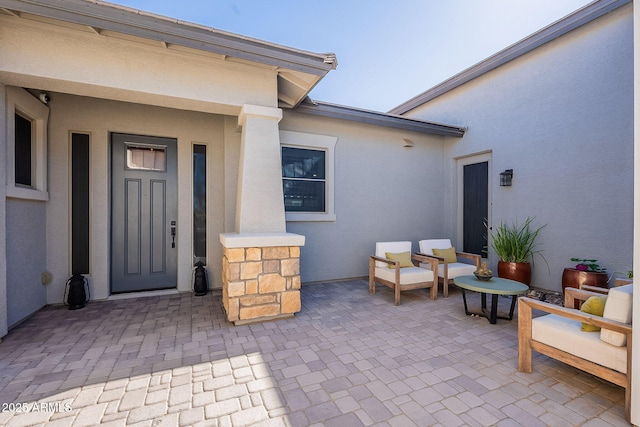 doorway to property featuring a patio area and stucco siding